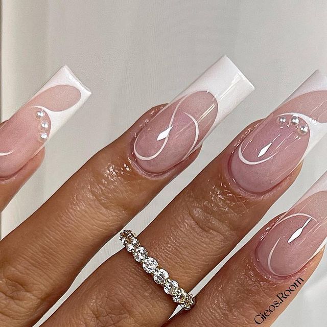 Sophisticated Nude and White Long Square Nail Design with Artistic Swirls and Pearl Accents