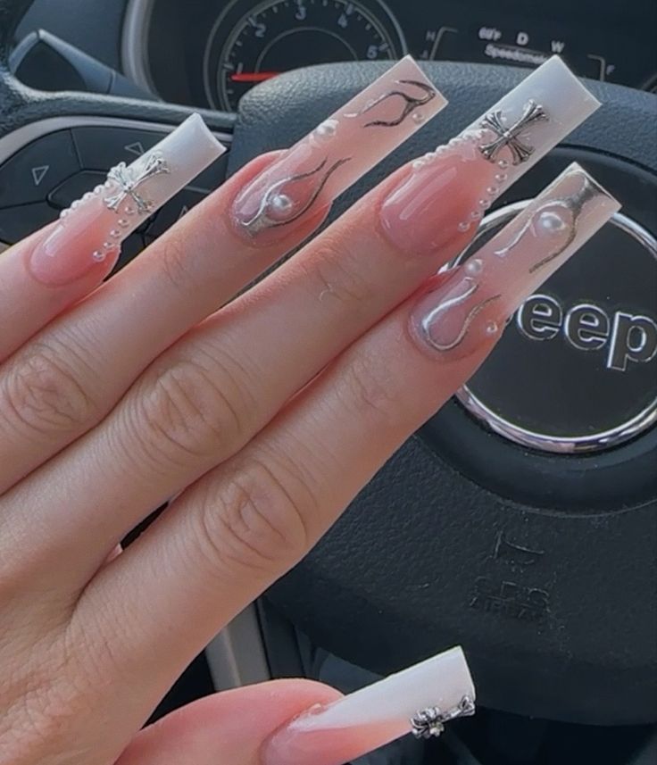 Elegant Nail Design: Clear and Nude Shades with Intricate Patterns and Glamorous Accents.