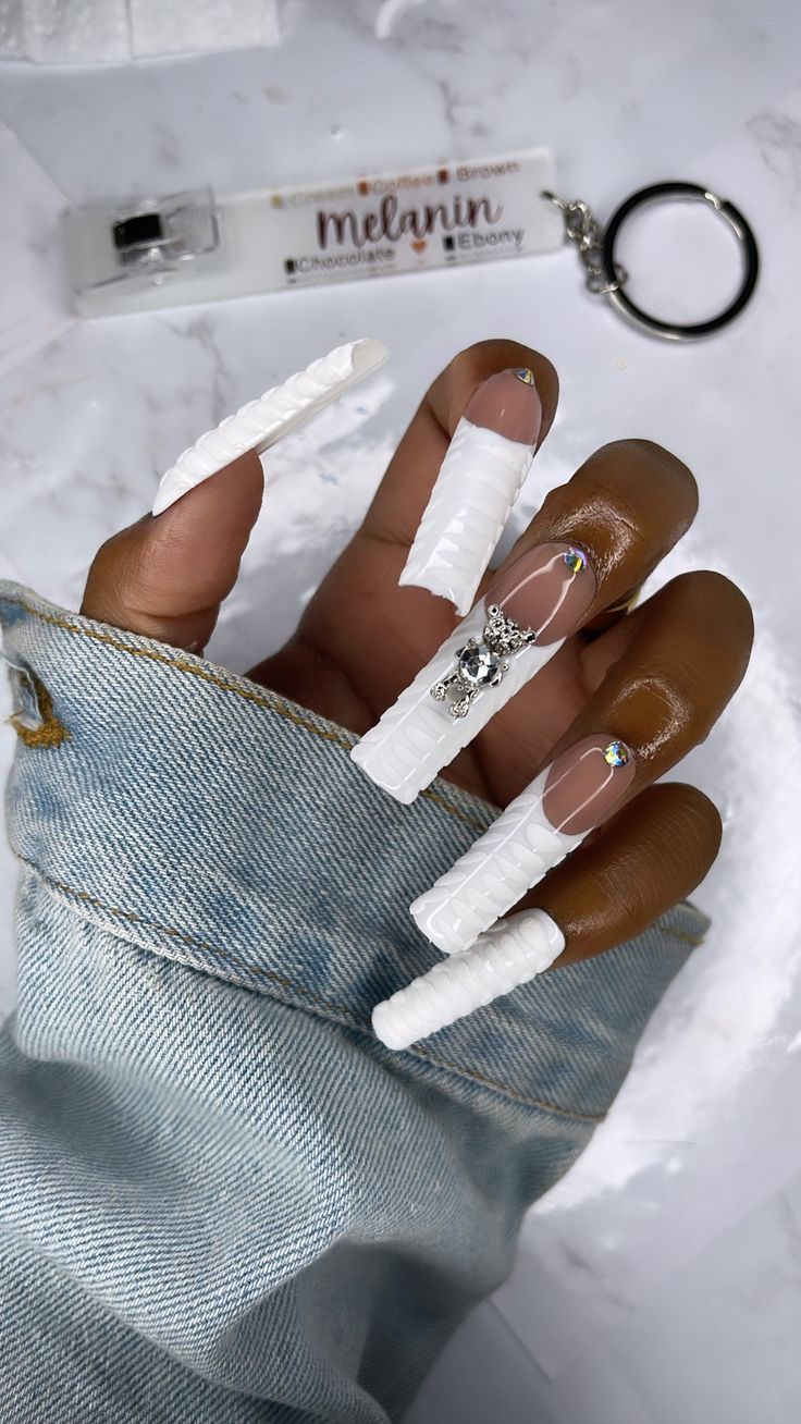 Elegant Avant-Garde White Nail Design with Sculpted Shapes and Rhinestone Accents.