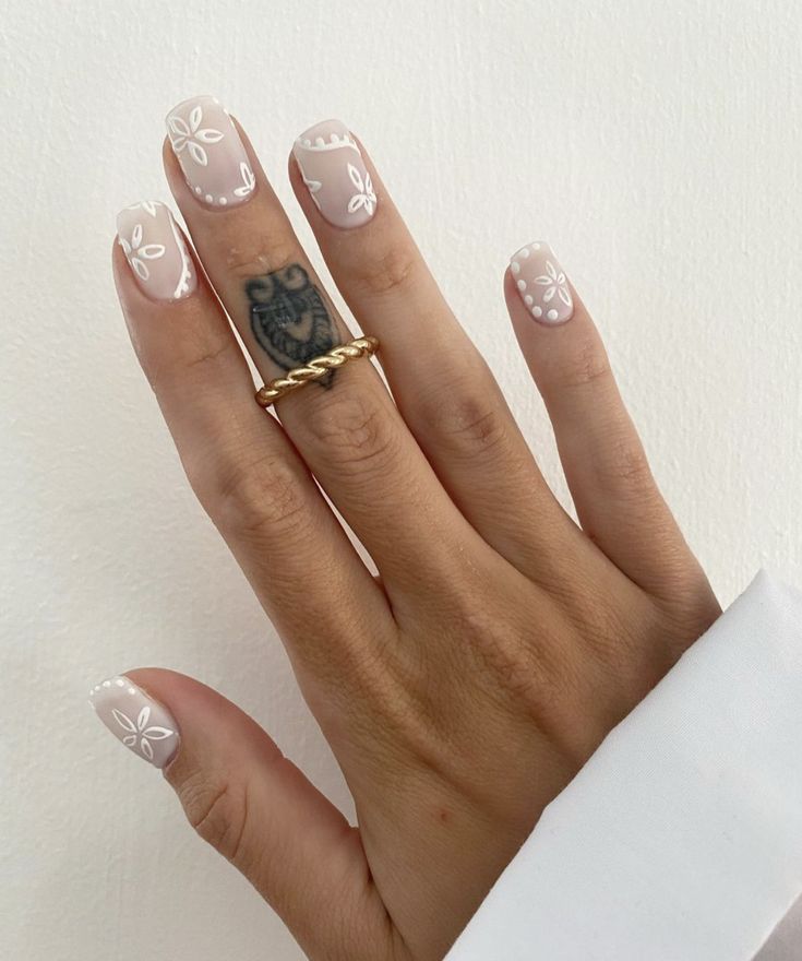 Charming Soft Beige Nails with Floral Designs Enhanced by Vintage Gold Ring.