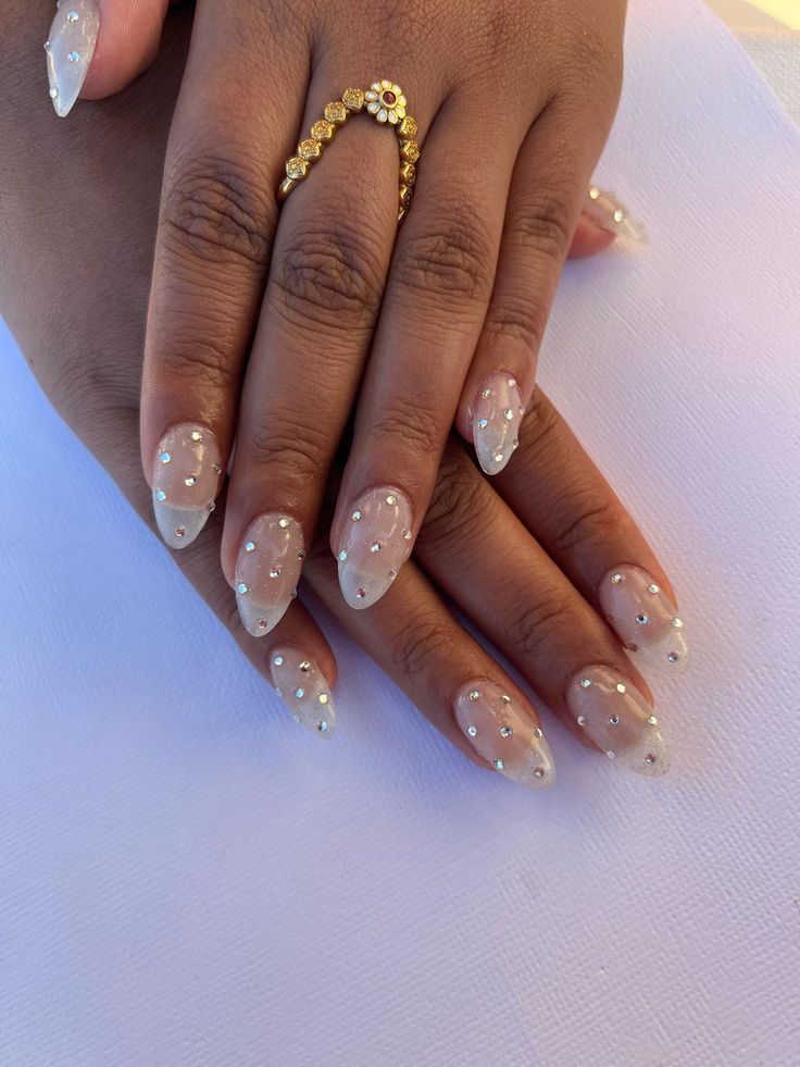 Sophisticated Almond-Shaped Nails: Subtle Nude Base with Delicate Crystal Embellishments.