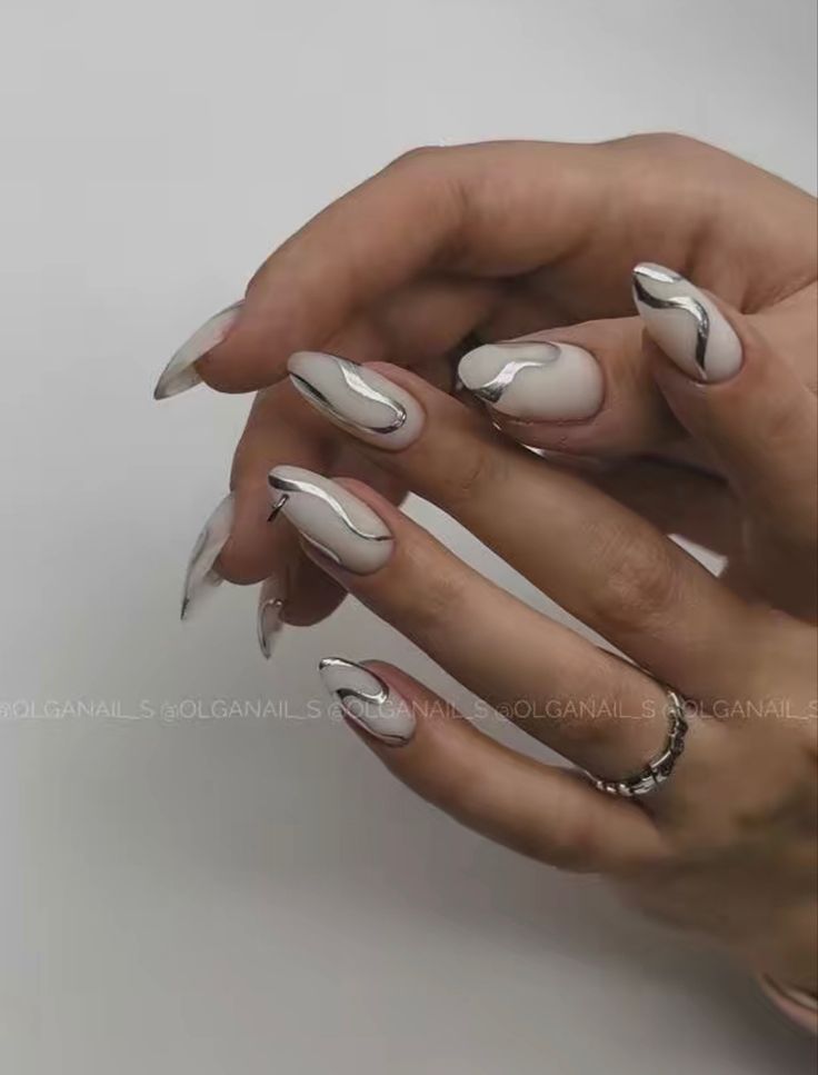 Chic Almond-Shaped Nails: Elegant Soft White with Metallic Silver Accents.