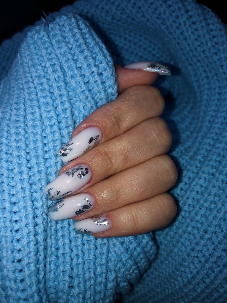 Chic Elegant Nail Design: Soft White Base with Striking Silver and Black Accents.