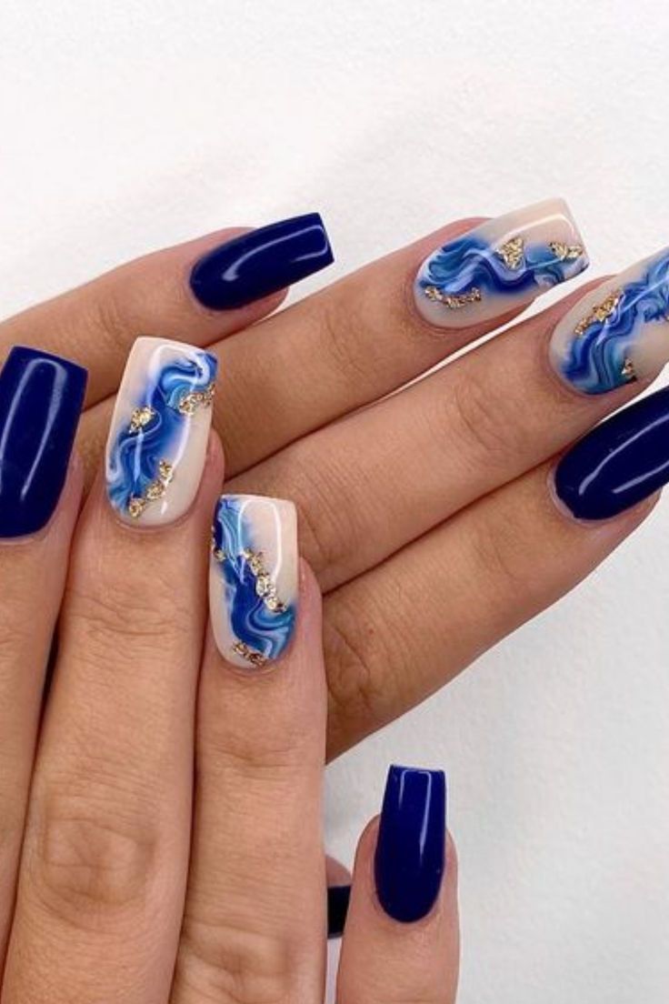 Chic Navy Blue Nail Design with Elegant Marble Effects and Luxurious Gold Accents