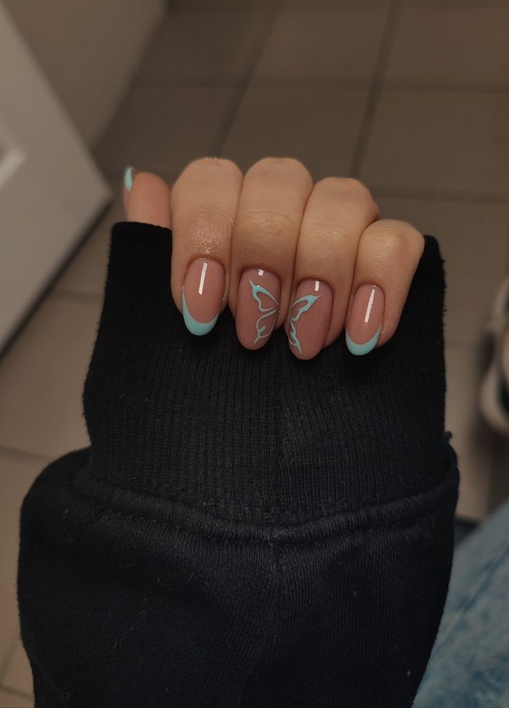 Elegant Nude Nail Design with Pastel Blue Accents and Artistic Butterfly Motifs