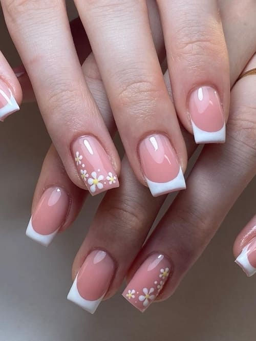 Elegant French Tip Nail Design with Soft Pink Base and Delicate Floral Accents