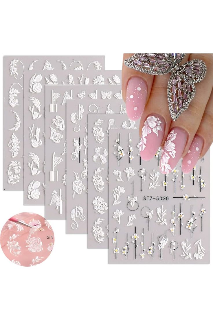 Elegant Floral Nail Design: Soft Pink with White Patterns and Sparkling Accents.