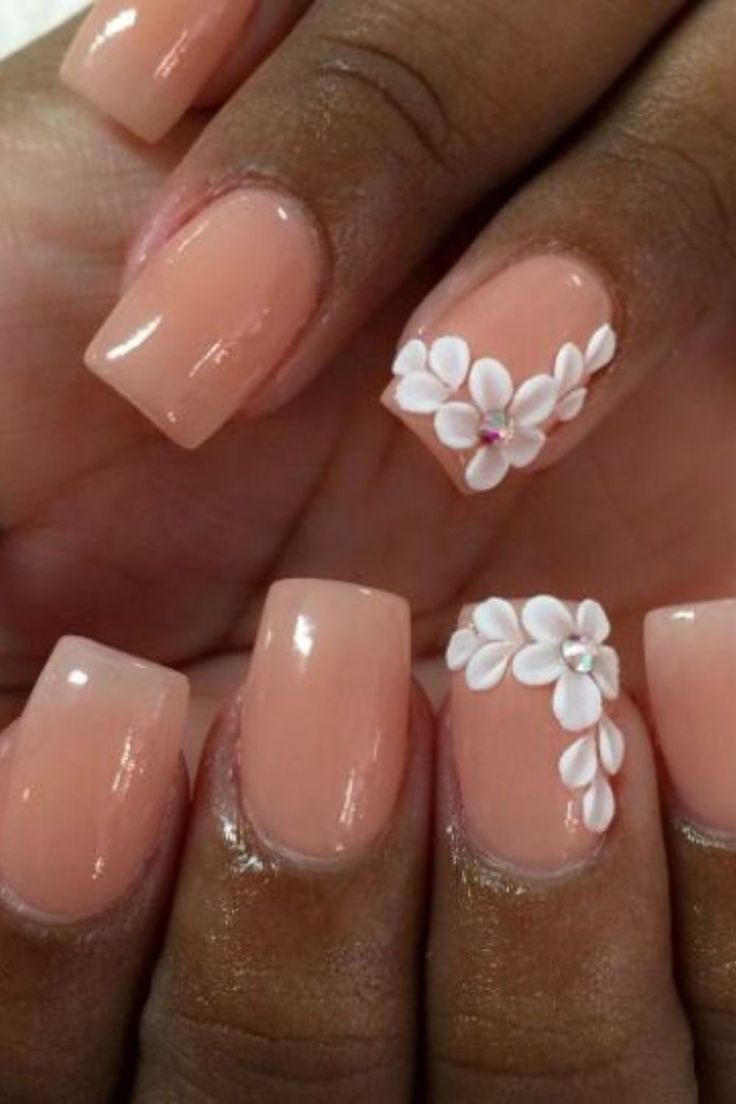 Chic Peach Nail Design with White Floral Accents and Rhinestones for Any Occasion.