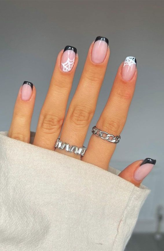 Chic French Manicure with Black Tips and Spider Web Art for a Modern Edge.