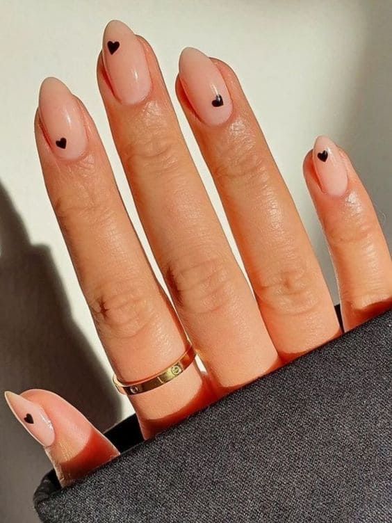 Elegant Nude Nail Design with Black Heart Accents