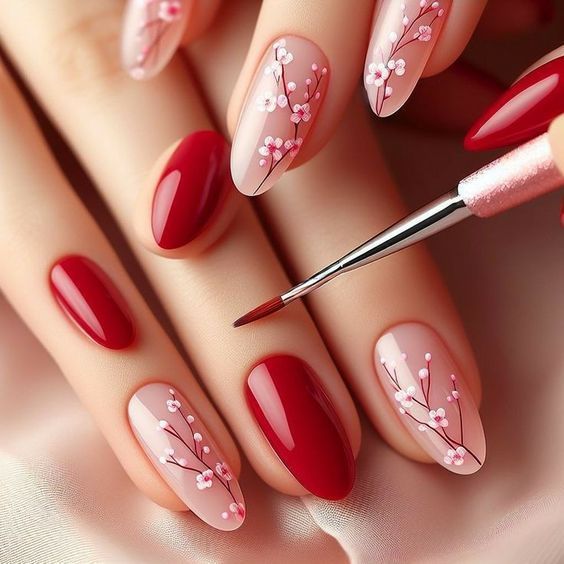 Chic Manicure: Deep Red and Soft Pink Elegance with Hand-Painted Floral Designs.