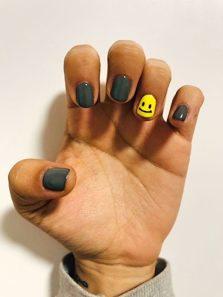 Playful Twist on Chic Dark Gray Nails with Cheerful Yellow Smiley Accent.