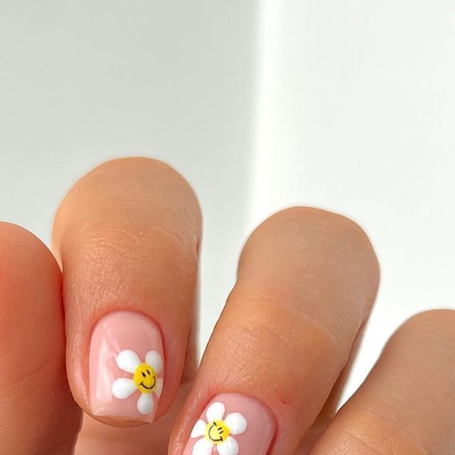 Whimsical Daisy Nail Design with Soft Pink Background