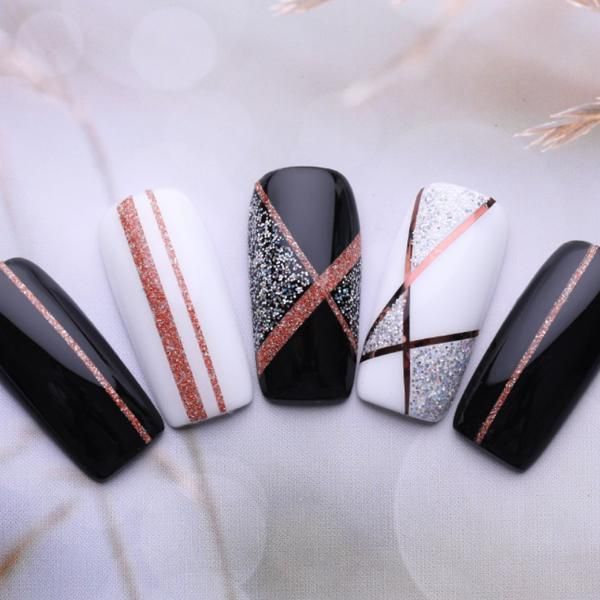 Sophisticated Chic Nail Design: Matte Black, Glossy White, and Rose Gold Accents with Modern Geometric Patterns.