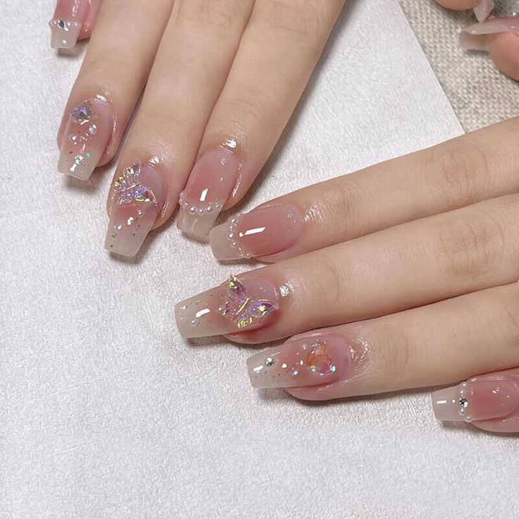 Whimsical Soft Pink Gradient Acrylic Nails with Butterfly Designs and Gem Accents