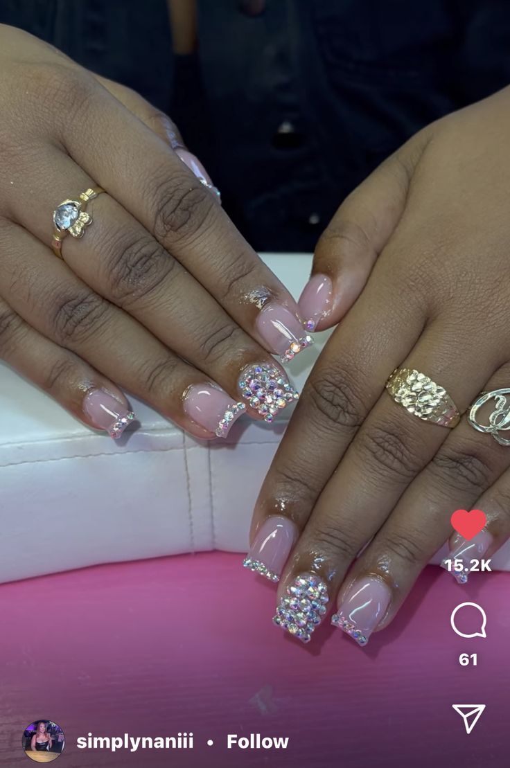 Sophisticated Soft Pink Nail Design with Sparkling Rhinestones and Glitter Tips.