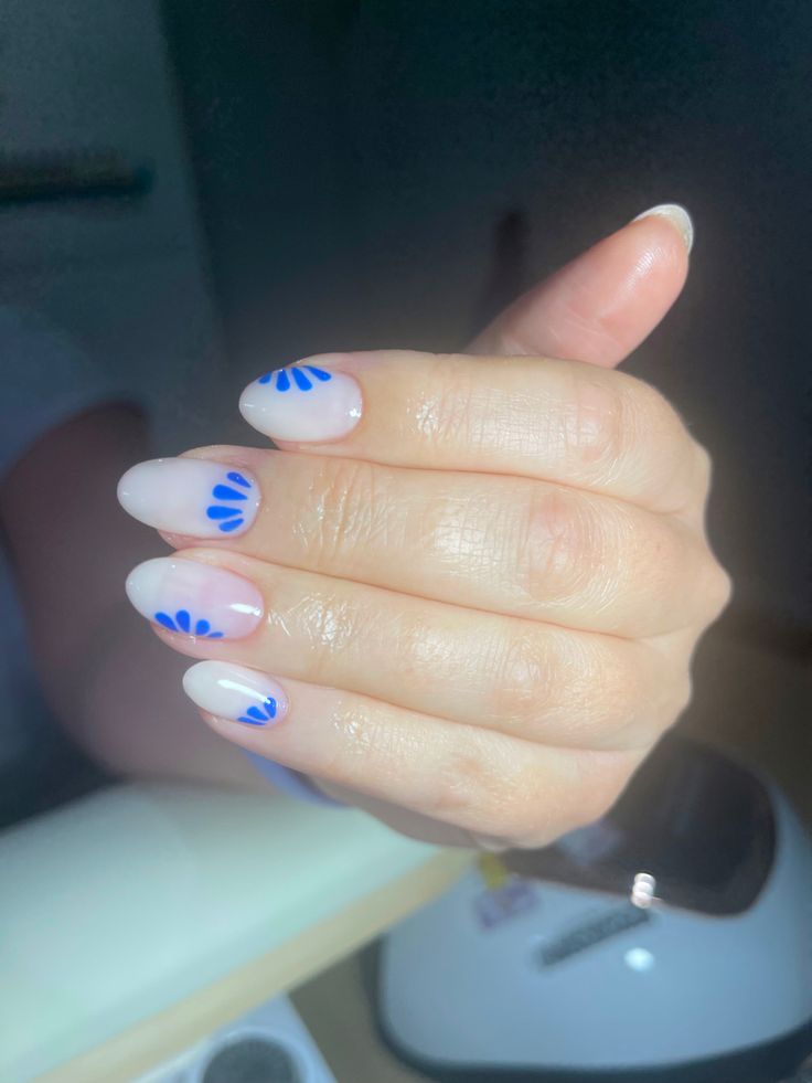 Chic Nail Design with Playful Soft Pink Base and Vibrant Blue Floral Patterns.