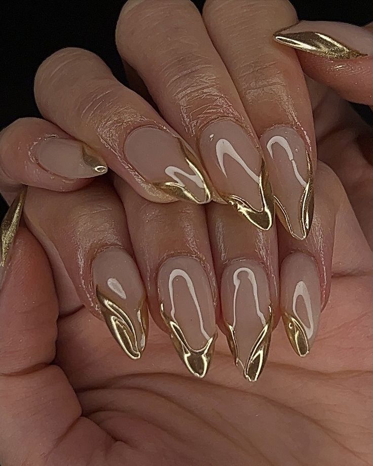 Stylish Nude Nail Design with Gold Accents and Elegant Finishes.