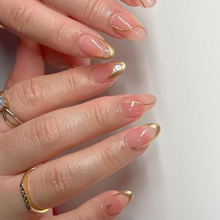 Sophisticated Nail Design: Soft Nude Base with Glossy Gold Tips and Modern Gold Accents.