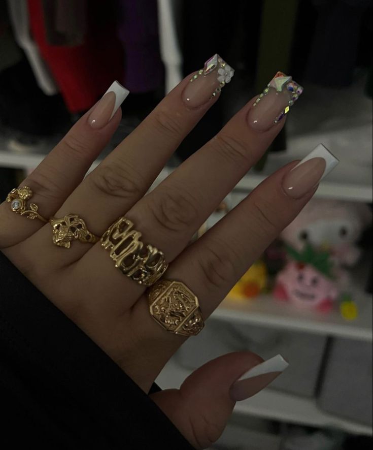 Chic French Manicure with Colorful Accent Nails and Glamorous Gold Ring Accents.