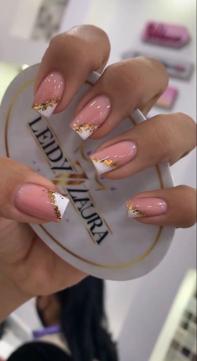 Chic Soft Pink Nail Design with French Tips and Glamorous Gold Glitter Accents.