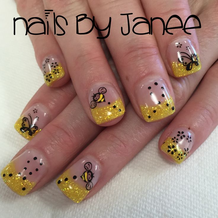 Vibrant Yellow Glitter Gradient Nail Design with Playful Bee and Floral Illustrations for Spring/Summer.