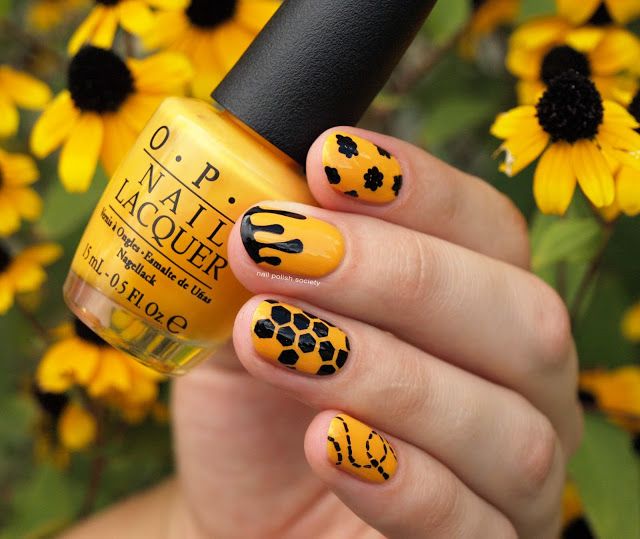 Vibrant Yellow Nail Design with Bold Black Patterns and Floral Backdrop for a Playful Summer Vibe