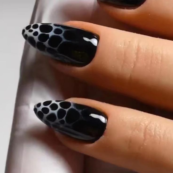 Elegant Almond-Shaped Black Nail Design with Glossy Finish and Artistic Negative Space Bubbles.