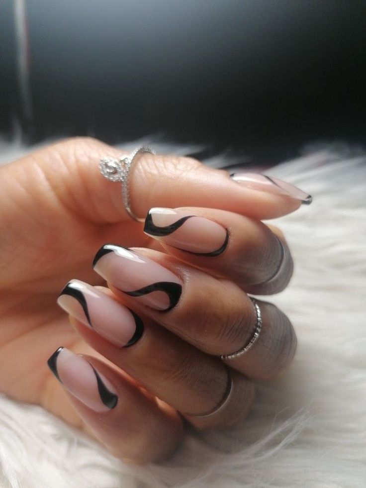 Sophisticated Nail Design: Soft Nude Base with Striking Black Swirls and Silver Accents.