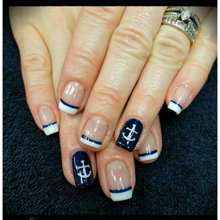 Nautical-Themed Nail Design: Chic Navy and White with Anchor Accents and Striped Tips.