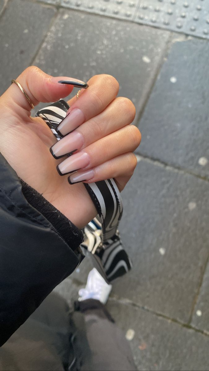 Elegant Almond-Shaped Gradient Nails: Chic Nude to Bold Black Tips for Any Occasion.