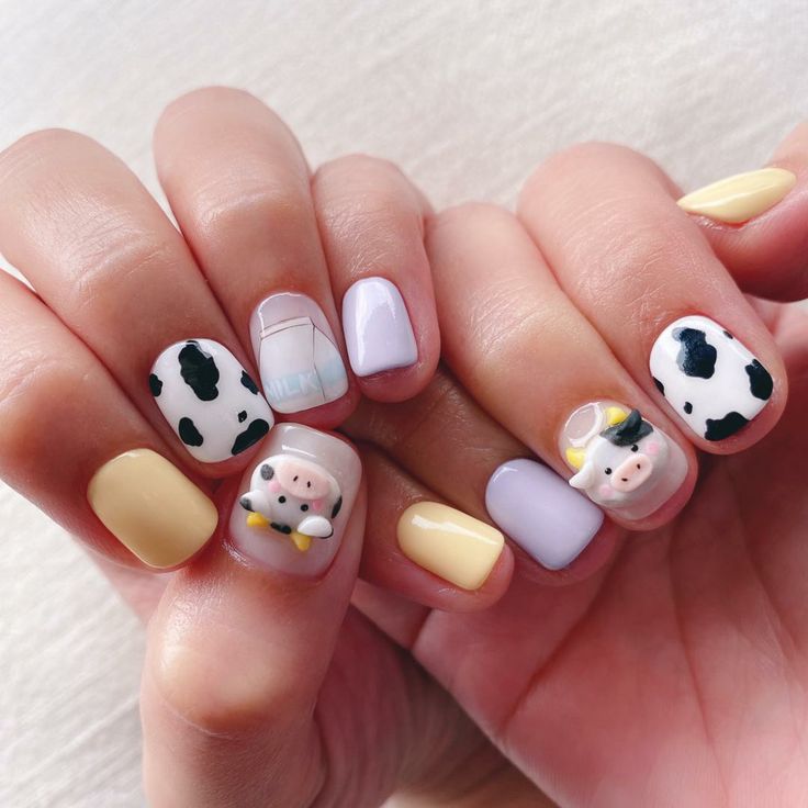 Whimsical Pastel Cow-Themed Nail Design with Cartoon Faces and Milk Carton Illustrations.