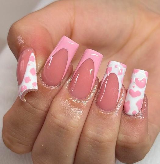 Chic Pink and White Nail Design with Whimsical Heart Patterns and Elegant Cutouts.