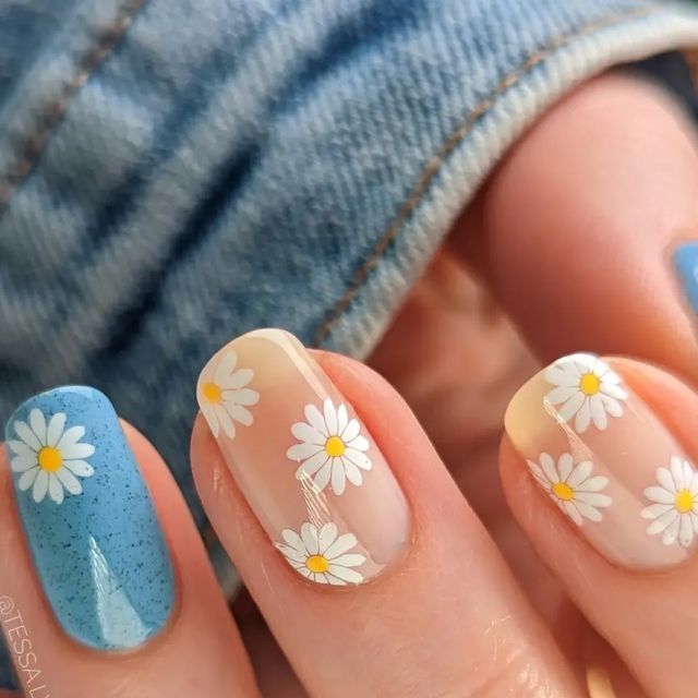 Playful Elegance: Floral Daisy Nail Design in Soft Blue and Clear Tones.