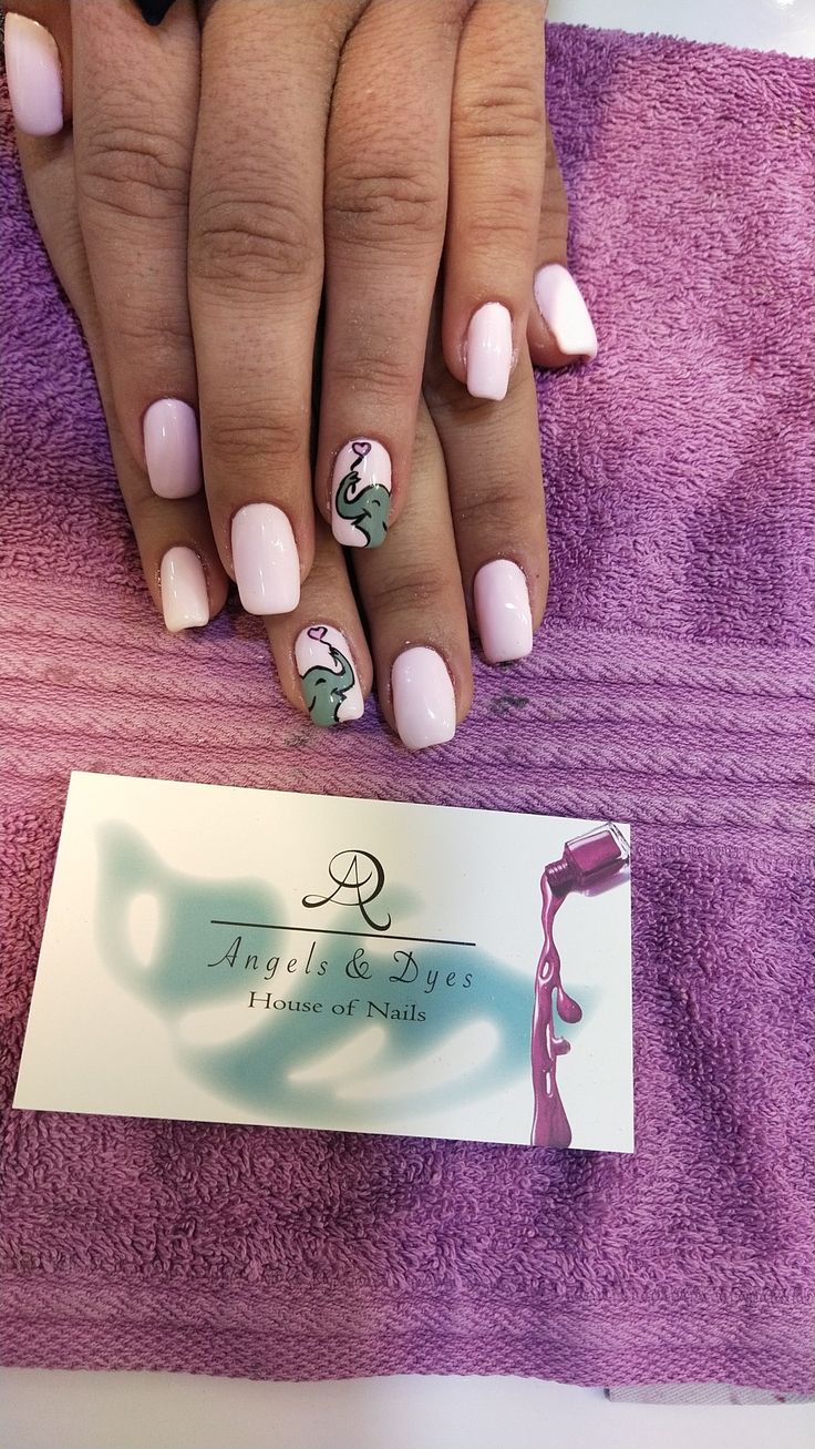 Charming Soft Pink Nail Design with Whimsical Illustrations for a Stylish Touch.