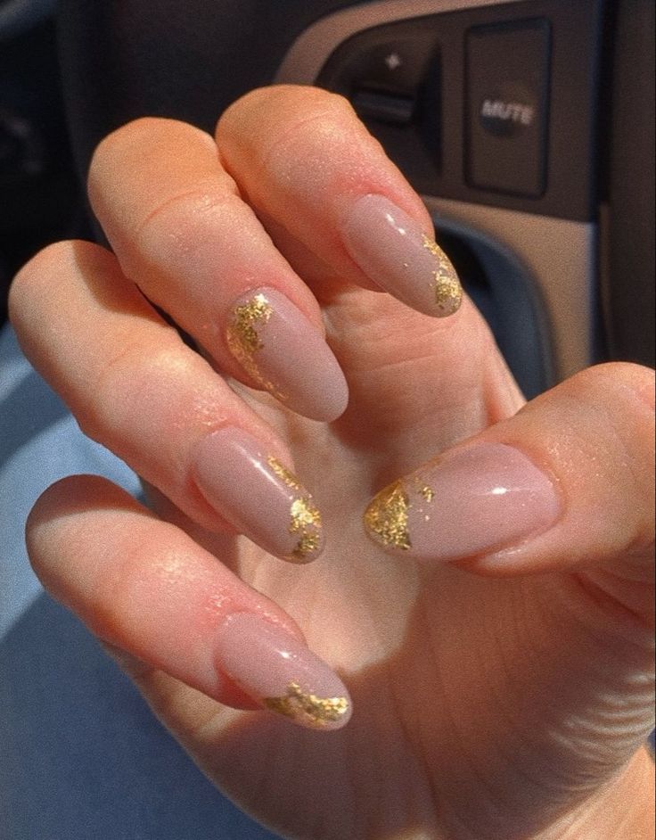 Chic Nude Nails with Glamorous Gold Accents and Sophisticated Length.