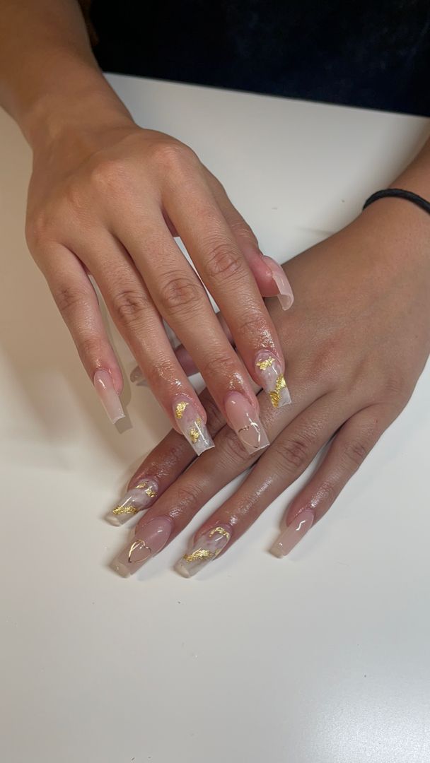 Sophisticated Nail Design: Soft Nude and Clear Polish with Glamorous Gold Leaf Accents.