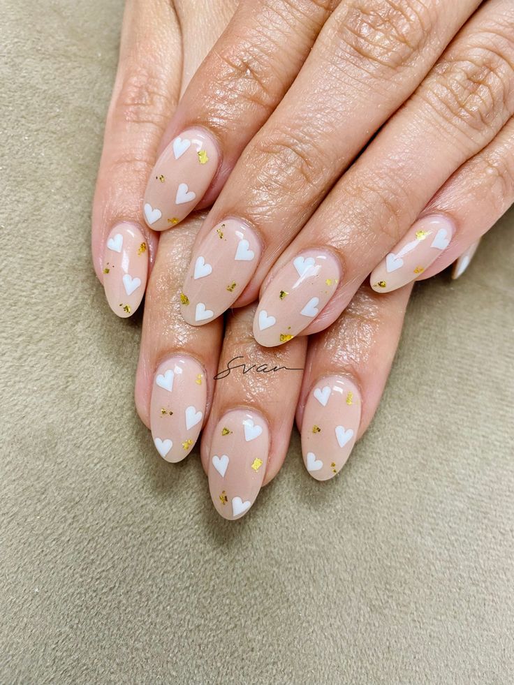 Cheerful Heart-Themed Nail Design with Elegant Gold Flakes on Soft Nude Base.