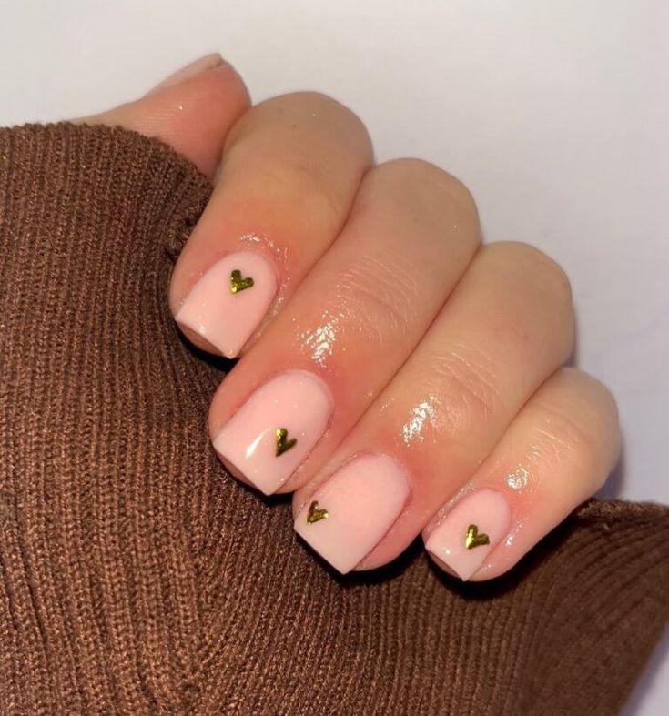 Elegant Minimalist Nail Design: Soft Pink Base with Golden Heart Accents.