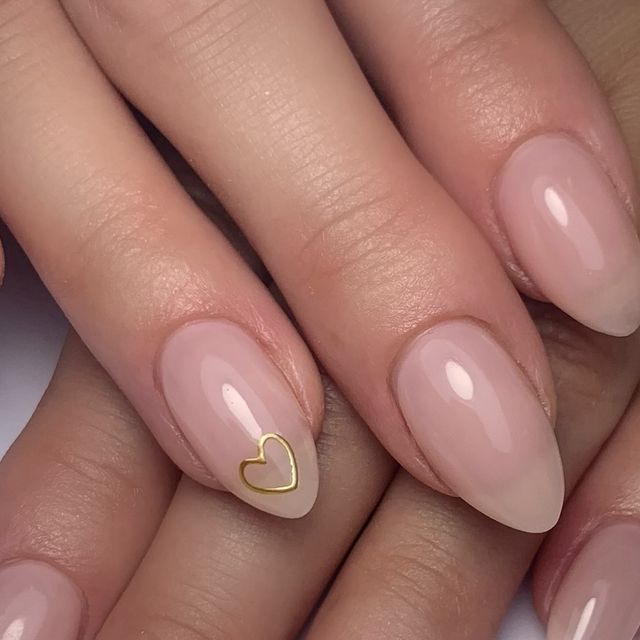 Elegant Soft Neutral Nail Design with Glossy Finish and Gold Heart Accent