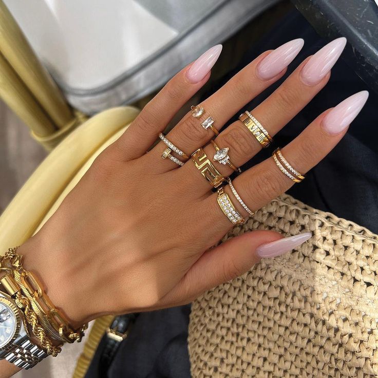 Chic Almond-Shaped Nails in Blush Pink Enhanced by Glamorous Accessories.