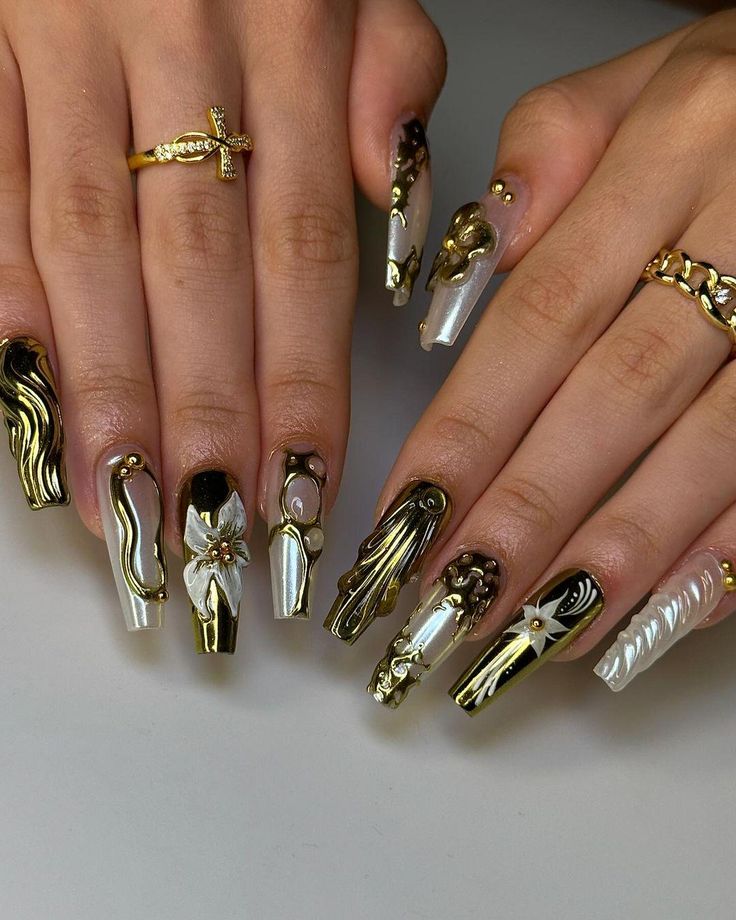 Elegant Black, Gold, and White Nail Design with Intricate Patterns and Bold Accents.