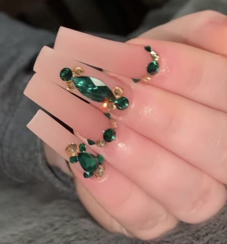 Sophisticated Long Nude Nail Design Accented with Green and Gold Rhinestones