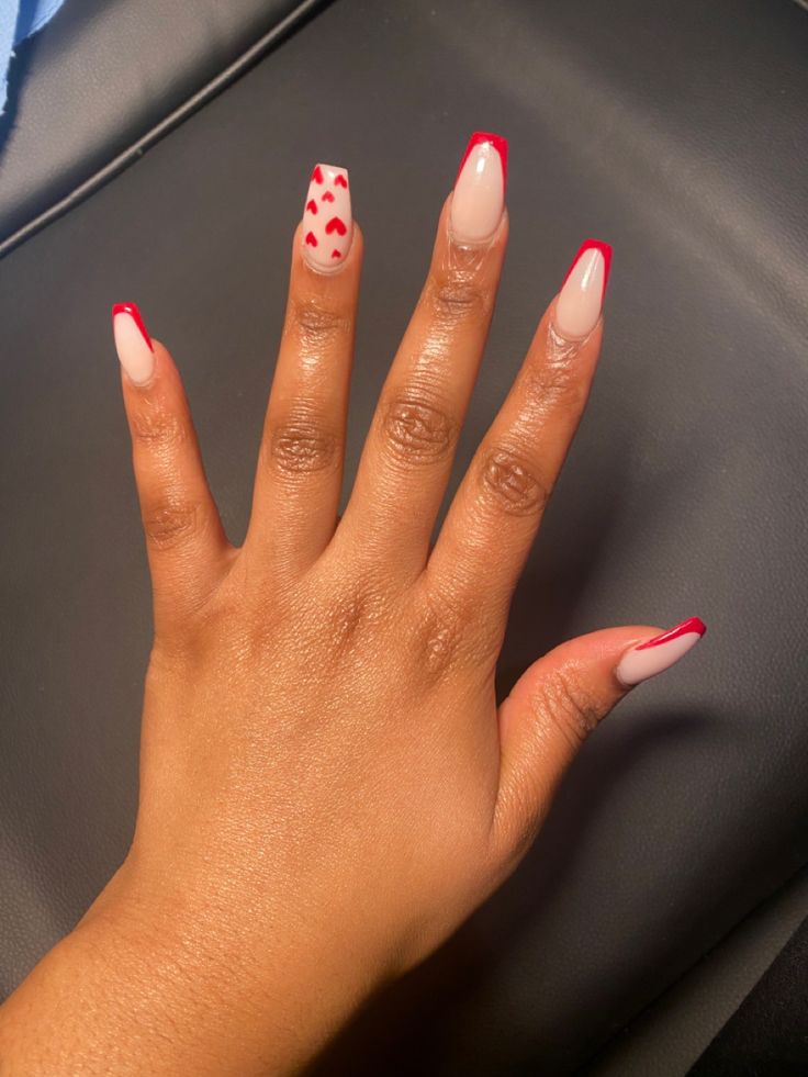 Chic Nude and Bold Red Nail Design with Playful Heart Accents.