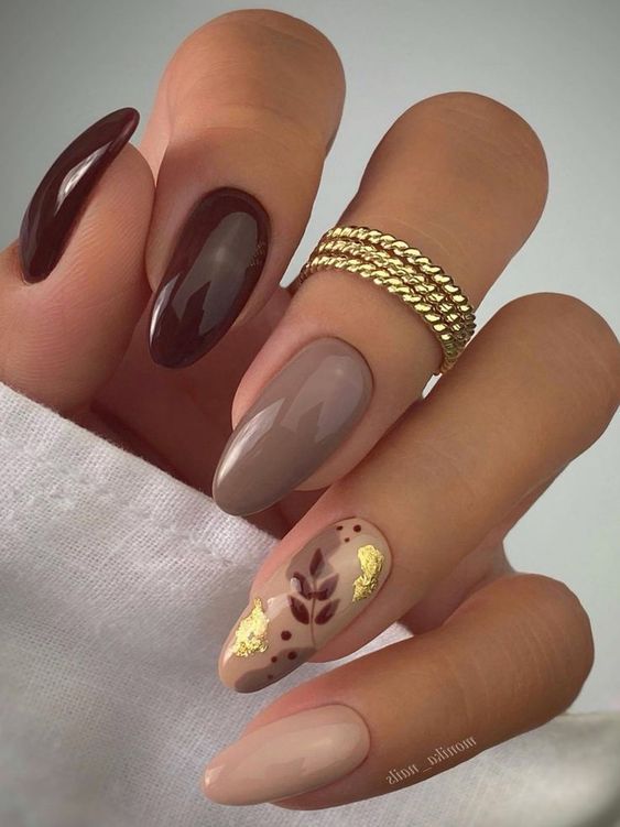 Chic Almond-Shaped Nail Design with Rich Brown, Soft Nude, and Golden Leaf Accents.