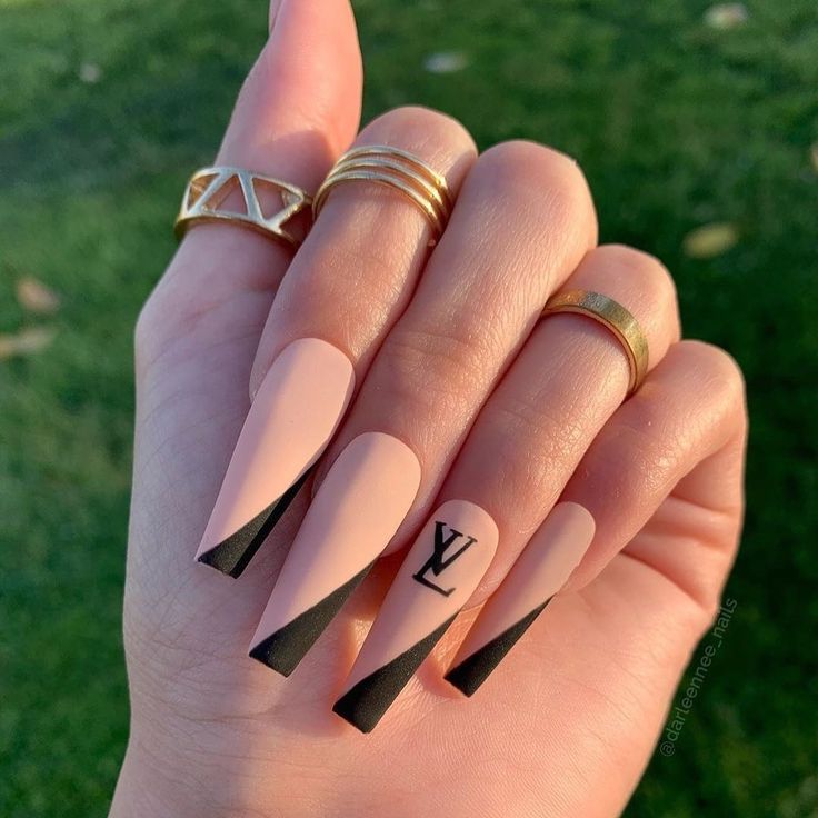 Sophisticated Almond-Shaped Nails: Nude Base with Bold Black Tips and Gold Accents.