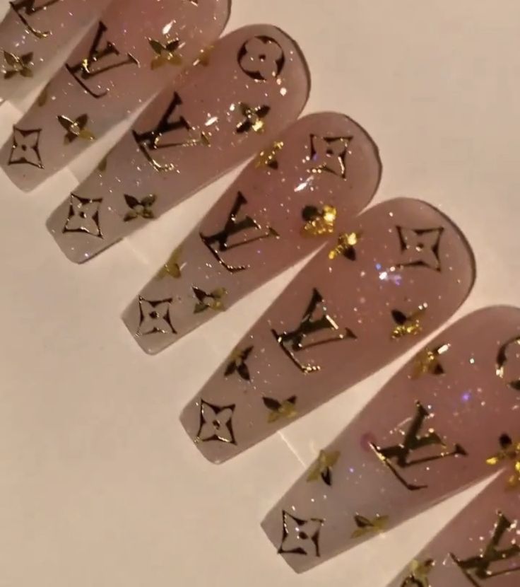 Luxurious Nail Art: Elegant Nude and Glitter Design with Black and Gold Patterns