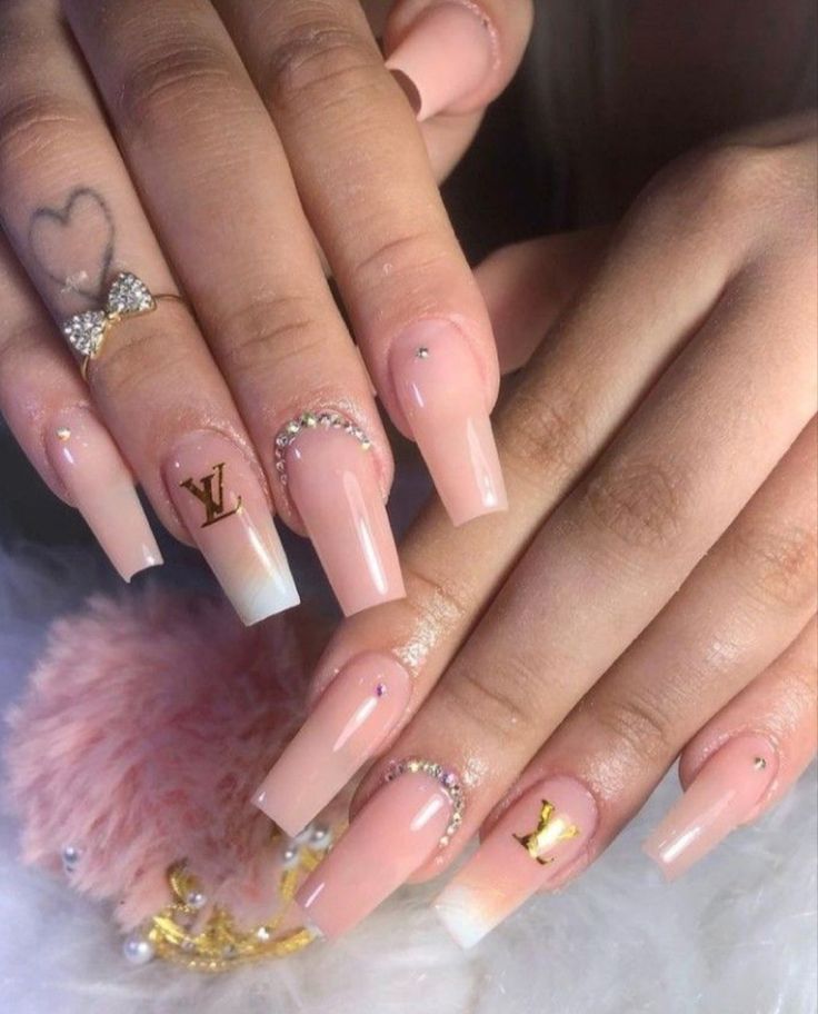 Luxurious Gradient Nude Nail Design with Gold Accents and Trendy Logo Details.