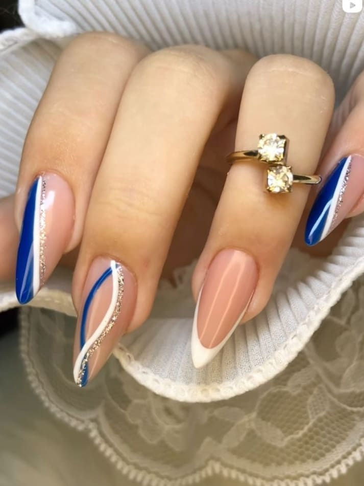 Chic Nude and Blue Nail Design with Elegant Lines and Silver Accents.