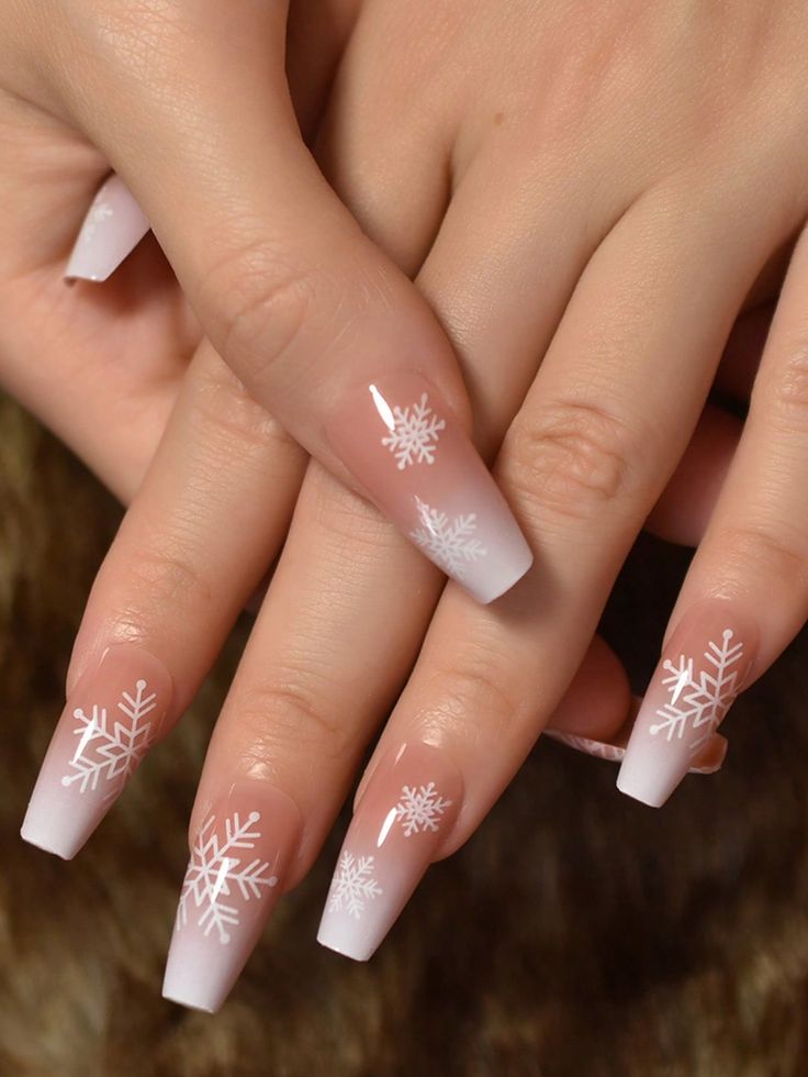 Elegant Winter Ombre Nail Design with Delicate Snowflake Patterns.